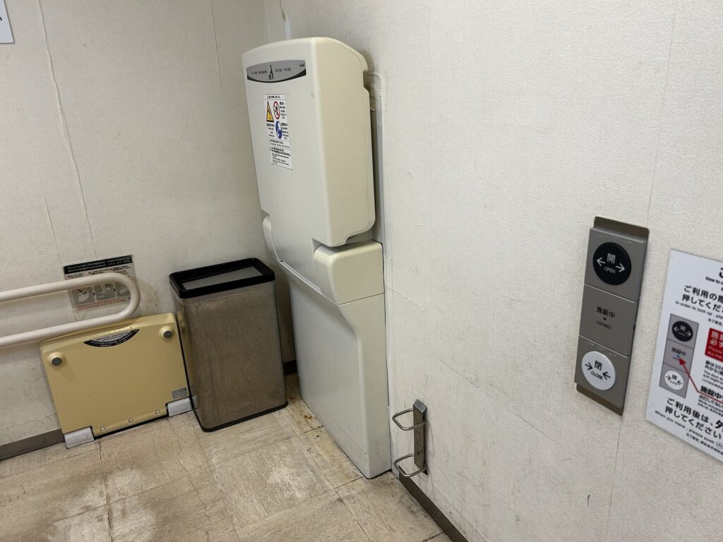 赤ちゃん用おむつ交換台と着替えボード、ドアの開閉ぼたん。